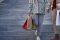 Real marriage detail of gay couple, holding hands, walking down some stairs and with many shopping bags in the other hand, happy Royalty Free Stock Photo