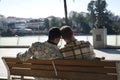 Real marriage of gay couple, holding hands, heads together and eyes closed, sitting on a wooden bench, complicit and happy, seen Royalty Free Stock Photo