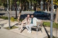 Real marriage of gay couple, holding hands, sitting on a wooden bench, talking accomplices and happy. Concept lgtb, lgtbiq+, Royalty Free Stock Photo