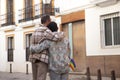 Real marriage of gay couple, hugging on the street, with a gay pride flag in their pocket and seen from the back. Concept lgtb,