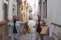 Real marriage of gay couple, walking down the street, hands full of shopping bags, happy and funny. Concept lgtb, lgtbiq+, couples Royalty Free Stock Photo