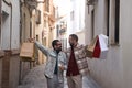 Real marriage of gay couple, walking down the street, hands full of shopping bags, happy and funny. Concept lgtb, lgtbiq+, couples Royalty Free Stock Photo