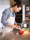 Real men cook. a handsome young man chopping vegetables in his kitchen. Royalty Free Stock Photo