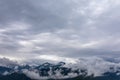 Real mountain landscape. Low clouds over mountains with snowy peaks. Twilight. High point of view Royalty Free Stock Photo