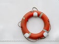 Real orange color lifebuoy hanging on white boat background. Royalty Free Stock Photo