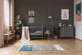 Real photo of a baby crib in a grey child`s room interior, next