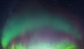 Real photo of beautiful soft Aurora Borealis - bright green curved lights on clear without clouds starry black night sky. A lot of Royalty Free Stock Photo