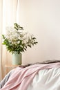 Real photo of bed with pink blanket in blurred foreground and be