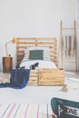 Real photo of a bedroom interior with a bed and pallet as a headrest Royalty Free Stock Photo