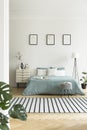 Real photo of bright bedroom interior with three simple posters, Royalty Free Stock Photo