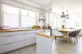 Real photo of bright kitchen interior with windows and dining ta Royalty Free Stock Photo