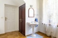 Real photo of a classic bedroom interior with doors, wash basin, mirror and window decorated with curtains Royalty Free Stock Photo