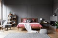 Real photo of a cozy bedroom interior with wooden bed in the mid Royalty Free Stock Photo