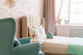 Real photo of a feminine bedroom interior with a comfy armchair, bed Royalty Free Stock Photo