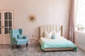 Real photo of a feminine bedroom interior with a comfy armchair, bed Royalty Free Stock Photo