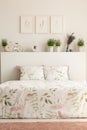 Real photo of floral bedroom interior with a double bed, pillows Royalty Free Stock Photo