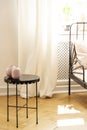 Metal table with a decorative vase in a bedroom interior
