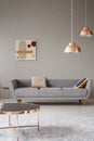 Minimalistic living room interior with a sofa, copper table and chandelier Royalty Free Stock Photo