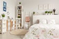 Real photo of a pastel bedroom interior with a double bed, flora Royalty Free Stock Photo