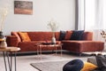 Rose gold table in warm living room interior with lots of cushions and a corner sofa Royalty Free Stock Photo