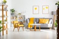 Real photo of a scandi living room interior with gray and yellow