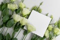 Real photo. square invitation card mockup with a eustoma flowers. Top view with copy space, light gray