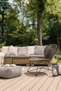 Real photo of a sunny terrace of a hostel with patterned pouf, b