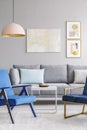 Real photo of two blue chairs standing in front of a grey couch Royalty Free Stock Photo