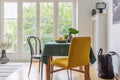 Vintage dining room interior with a table, yellow chair and big balcony window Royalty Free Stock Photo