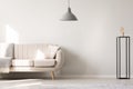 Real photo of a white sofa with cushion and blanket standing nex