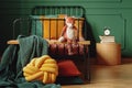 Real photo of a knot pillow, green blanket and plush fox on a wooden bench in front of a black bed in cute bedroom interior