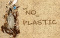 Real plastic bottle, with cap and plastic straw washed up on beach mixed with seaweed shells and feathers. Say no to plastic text