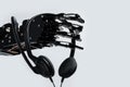 Real robot& x27;s hand with headset. Concept of Artificial intelligence and Chatbots usage in online business