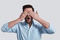Real shock. Surprised young man covering eyes with hands while Royalty Free Stock Photo