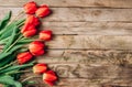 Real spring red tulips on a rustic wooden background. Spring flowers for Mother`s Day. Top view Royalty Free Stock Photo