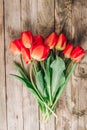 Real spring red tulips on a rustic wooden background. Spring flowers for Mother`s Day. Top view Royalty Free Stock Photo