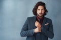 Real style from a real man. Studio shot of a handsome and dapper young man posing against a grey background.