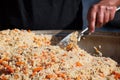 Real traditional street pilaf or plov, rice dish cooking in stock or broth