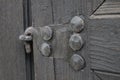 Real wooden texture with a hand-wrought iron element. Wood with iron background. A wooden door with an iron lock of old times. Old Royalty Free Stock Photo