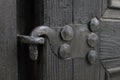 Real wooden texture with a hand-wrought iron element. Wood with iron background. A wooden door with an iron lock of old times. Old Royalty Free Stock Photo