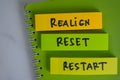 Realign, Reset, Restart write on sticky notes isolated on Wooden Table Royalty Free Stock Photo