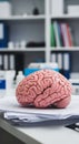 Realistic anatomical model of a human brain resting on a stack of documents Royalty Free Stock Photo