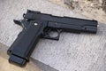 Realistic black airsoft gun lying on stone outdoors Royalty Free Stock Photo