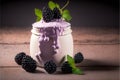 Realistic blackberry yogurt in a glass jar on blackberry background with copyspace.