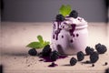 Realistic blackberry yogurt in a glass jar on blackberry background with copyspace.