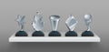 Realistic bookshelf with trophies. 3D transparent glass awards on black stands. Blank winner prizes, creative or