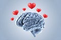 Realistic brain on light blue background, with floating red hearts symbolizing emotion
