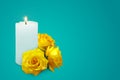 Realistic candle and yellow rosebuds on a blue background. Royalty Free Stock Photo