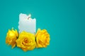 Realistic candle and yellow rosebuds on a blue background. Royalty Free Stock Photo