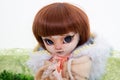 Realistic doll toy scary portrait in fashion clothes in green background